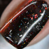 I Miss You Nail Polish - Special Edition, close-up of the nail polish with glitter and holographic particles in a dark red and black base.