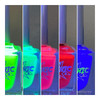 Blue Flame Neon Shimmer Nail Polish, displays five bottles of neon nail polish in green, turquoise, pink, red, and blue with a shimmering, glowing effect under blacklight.