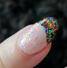 Emotional Rollercoaster Confetti Nail Polish - All Emotions Topper, close-up of a manicured fingernail with holographic confetti glitter nail polish on a clear base, with a black tip featuring colorful confetti flakes.