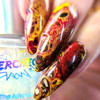 Flush Sheer Red Aurora Nail Polish - Fluid Art Topper Polish - Glow in the Dark Effects, close-up of nail polish with swirling red, yellow, and black patterns with metallic accents.