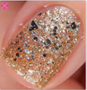 Chronicles Of The Dreamcatcher - Genuine Diamond Nail Polish, close-up of a fingernail painted with glittery gold nail polish featuring shiny black and silver embellishments.