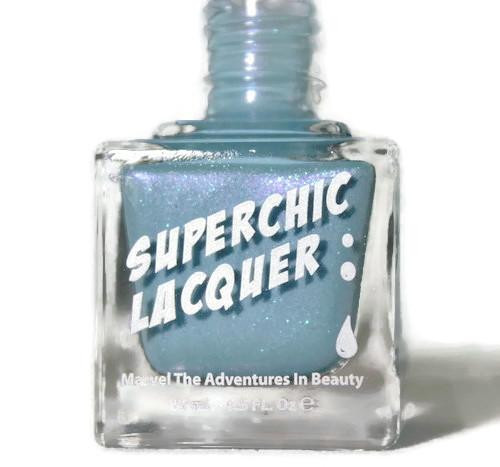 Coming Unblued Nail Polish, a glass bottle of blue nail lacquer with glitter and white text on the label.