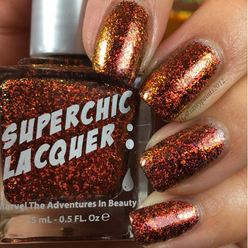 Crown Of Thorns Nail Polish, red and gold glittery nail polish on fingernails.