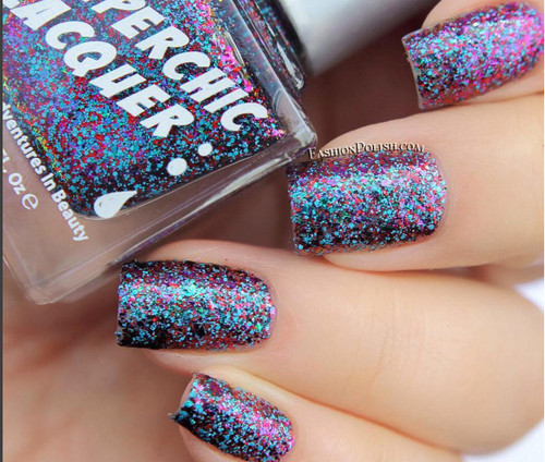 Quickening Nail Polish, glitter nail polish with multicolored glitter particles on neatly manicured nails.