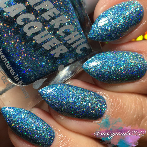 Own It Nail Polish, glittering blue holographic nail polish applied on nails.