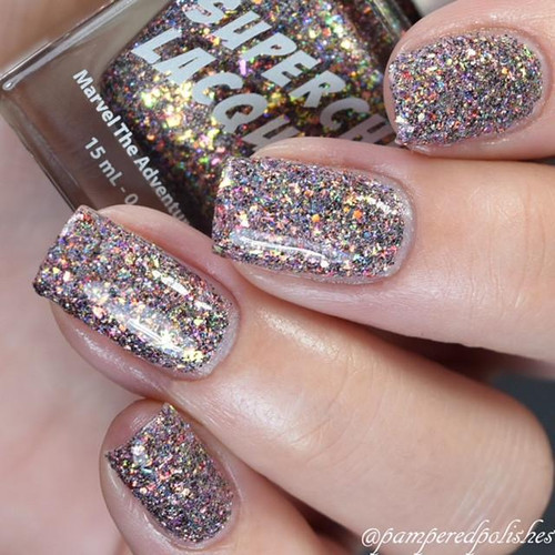 Love Is A Battlefield Nail Polish, close-up of glittery, holographic nail polish on fingernails with the bottle in the background.