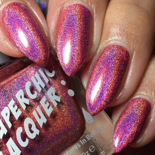 Exposed Nail Polish, close-up of nails painted with holographic, multicolor shimmer nail polish showing vibrant pink, purple, gold, and orange hues.
