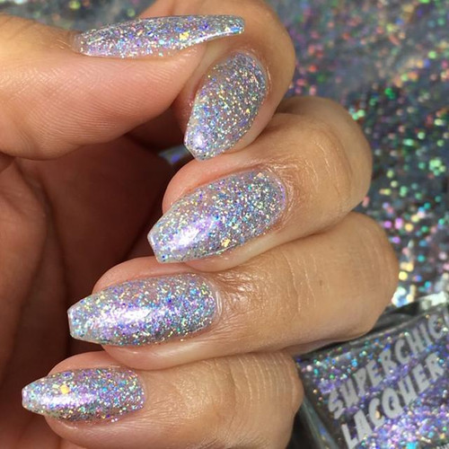 Spoonful Of Sugar Plum Nail Polish, close-up of a hand with long, almond-shaped nails painted with glittery, iridescent holographic nail polish.