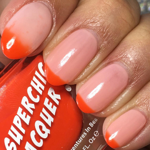 Amused Thermal Nail Polish, close-up of nails with a natural pink base color and vibrant orange tips, showcasing the color-changing effect of the thermal nail polish.