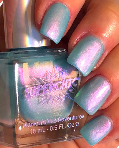 Unreal Nail Polish, iridescent light blue and pink holographic nail polish on manicured nails.