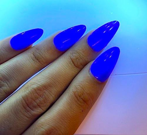 Blue Flame Neon Shimmer Nail Polish, vibrant blue nail polish applied on fingernails with a neon shimmer effect under bright lighting.