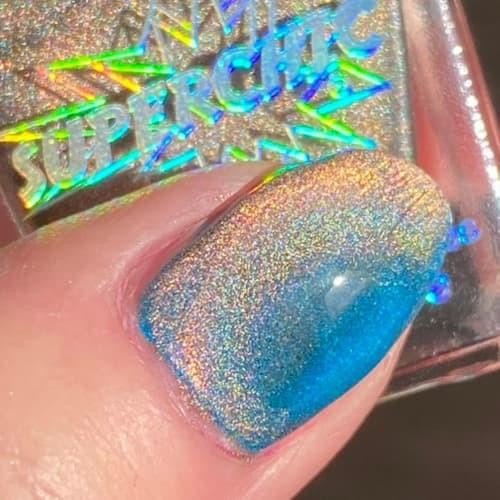Copper Bengal Holographic Multichrome Magnetic Cat Eye Topper Nail Polish, close-up of a nail painted with holographic multichrome nail polish in blue and copper hues with a magnetic cat eye effect.