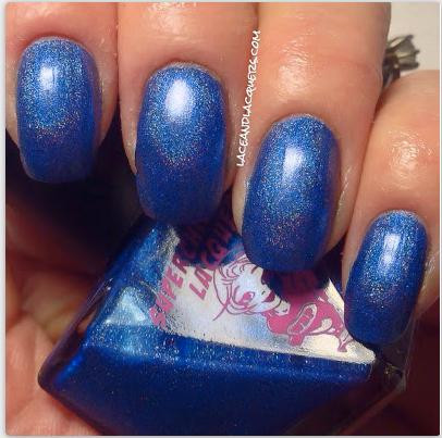 Tripped Nail Polish, close-up of four manicured nails painted with shimmering blue nail polish with gold glitter accents.