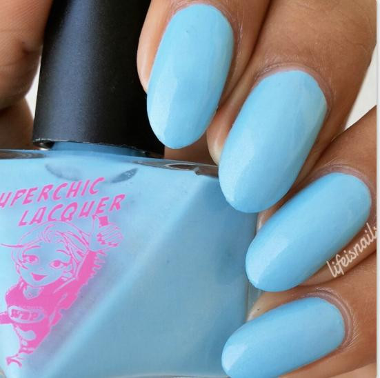 Crystal Blue Persuasion Nail Polish, bottle of sky-blue nail polish with freshly painted nails showing the color application.