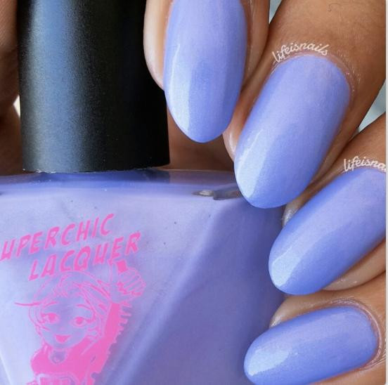 Synchronicity Nail Polish, light purple painted nails with a glossy finish next to the nail polish bottle.