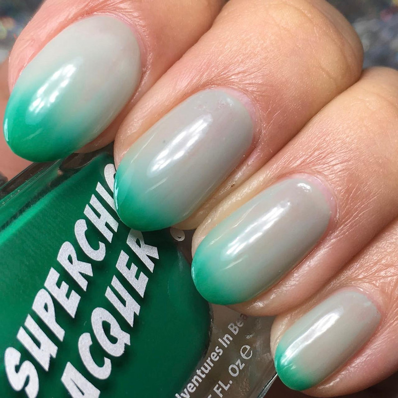 Anxious Thermal Nail Polish, hand showing nails with color-changing gradient from white to turquoise.