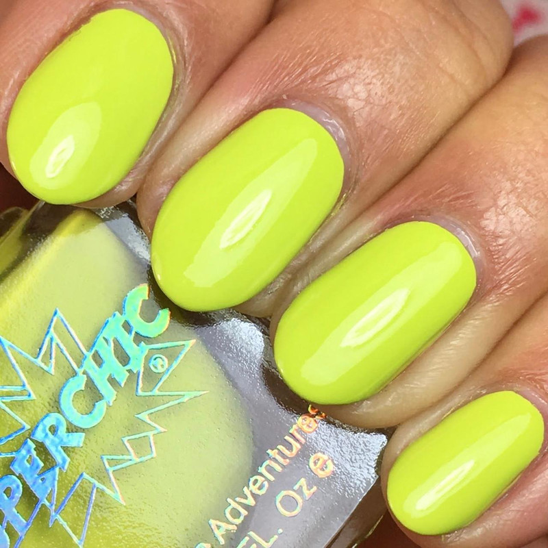 Suck It Nail Polish, bright yellow-green nail polish on manicured fingernails.