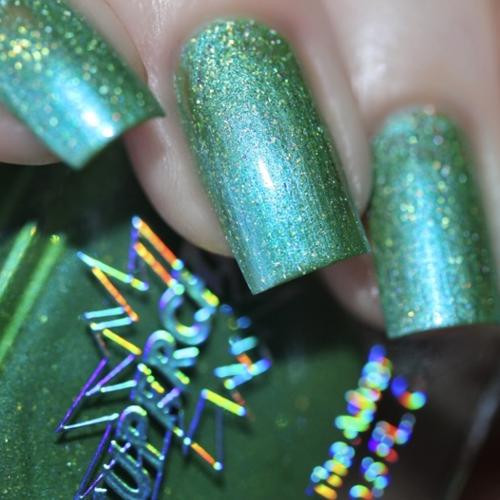 Forever Neverland Nail Polish, close-up of green shimmering nail polish with glitter on fingernails.