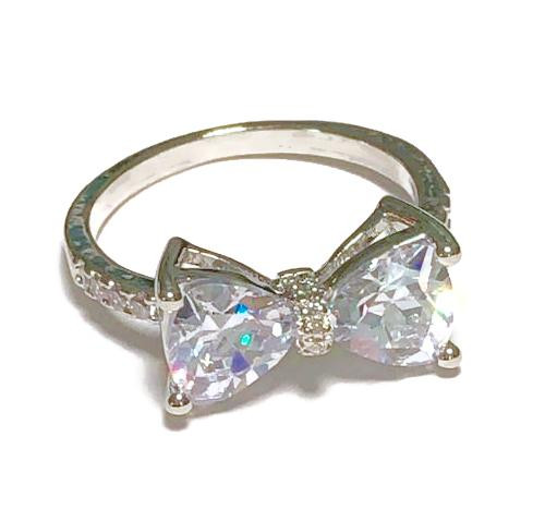 Dazzling Bow Ring - White Faux Diamond - 925 Sterling Silver, a silver ring featuring a bow-shaped design adorned with sparkling white faux diamonds.