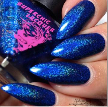 Lucid Lala Land Nail Polish, close-up of fingernails painted with shimmering blue nail polish with glitter accents.