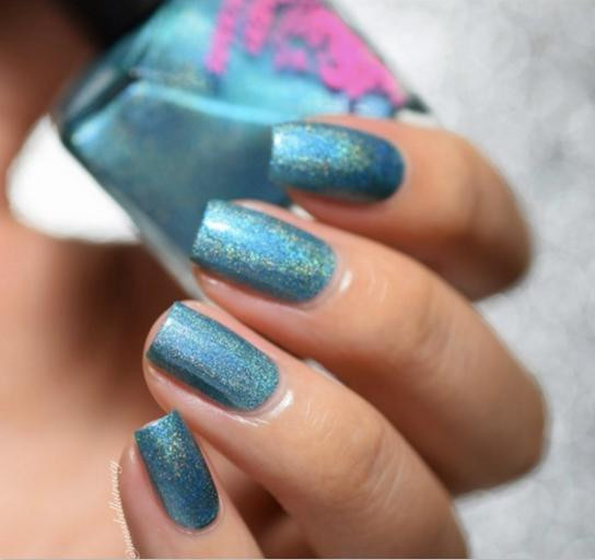 Splice Nail Polish, vibrant blue nail polish with glittery finish on well-manicured nails