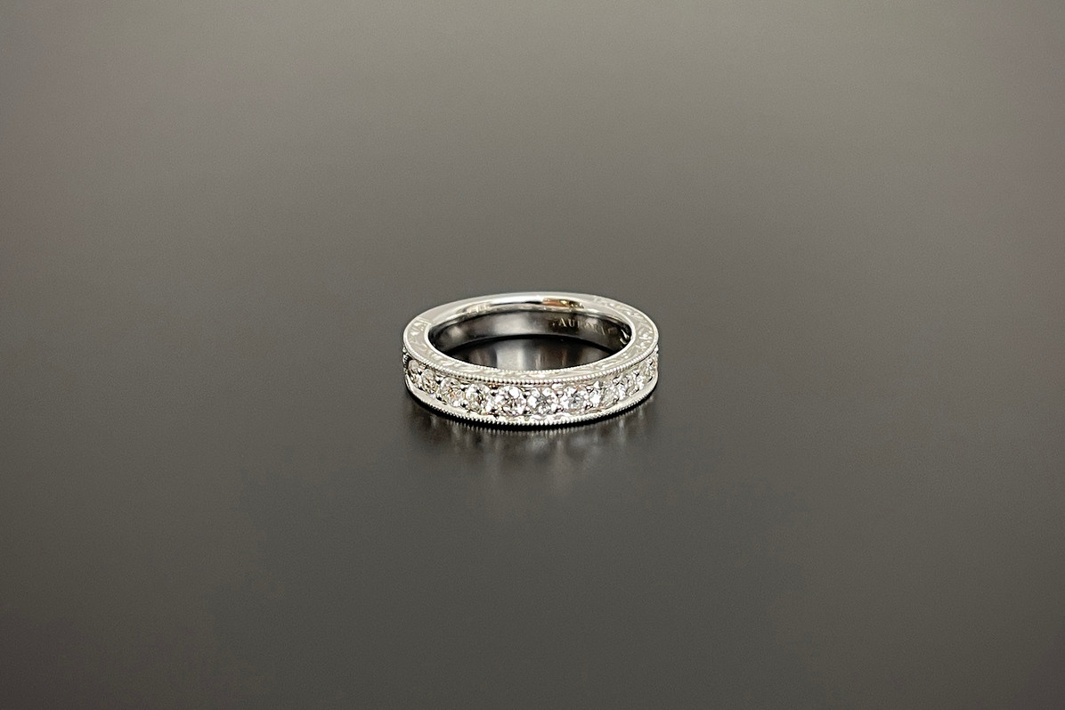 A Divine Diamond Anniversary Ring
Featuring thirteen round brilliant cut diamonds delicately claw set in a millegrain border.
Having finely engraved detail to the edge of the band 3/4 of the way around.
18ct white gold.
