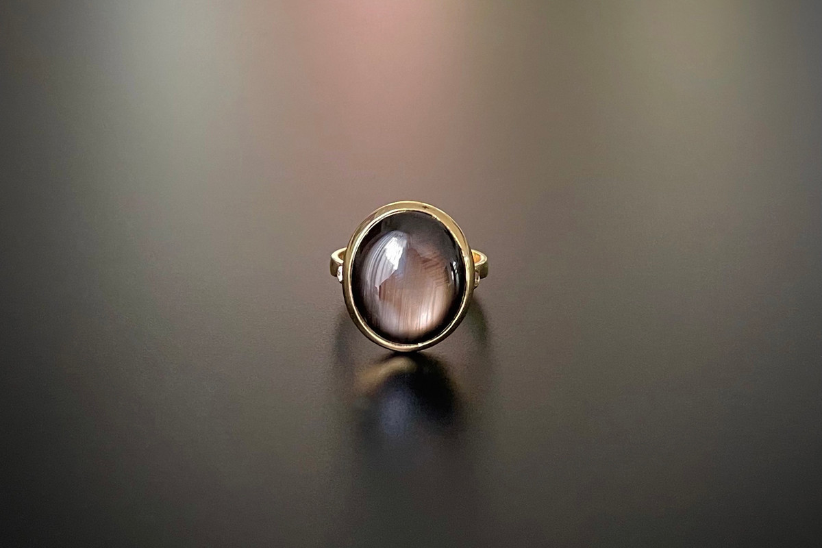 A Striking Star Sapphire and Diamond Ring
Oval brown sapphire cut en cabochon
Bezel set with a small brilliant cut diamond set to each shoulder
18ct yellow gold
Sapphire: 15.22cts
Diamonds: 0.04cts
Colour: G
Clarity: VS