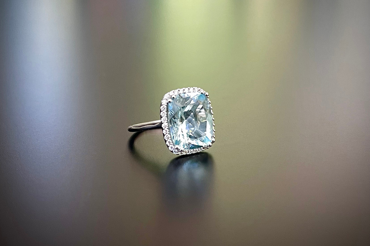A Stunning Aquamarine and Diamond Cluster Ring.
Comprising a cushion cut aquamarine, surrounded by a halo of round brilliant cut diamonds.
18ct white gold.
Aquamarine weight: 8.37cts.
Total diamond weight: 0.35ct.
Colour: F-G
Clarity: VS -SI1
Total weight: 7.20gms
Size: M1/2.