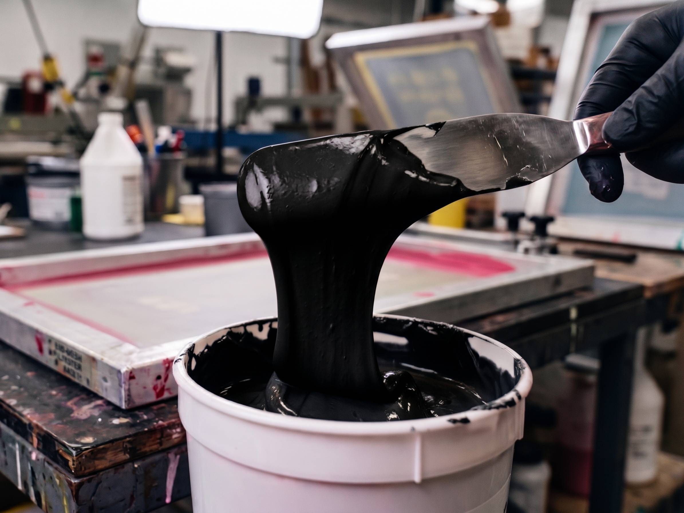 Texsource GEN Series Black 11900 plastisol ink lifted with stainless spatula showing buttery viscosity and deep black tone