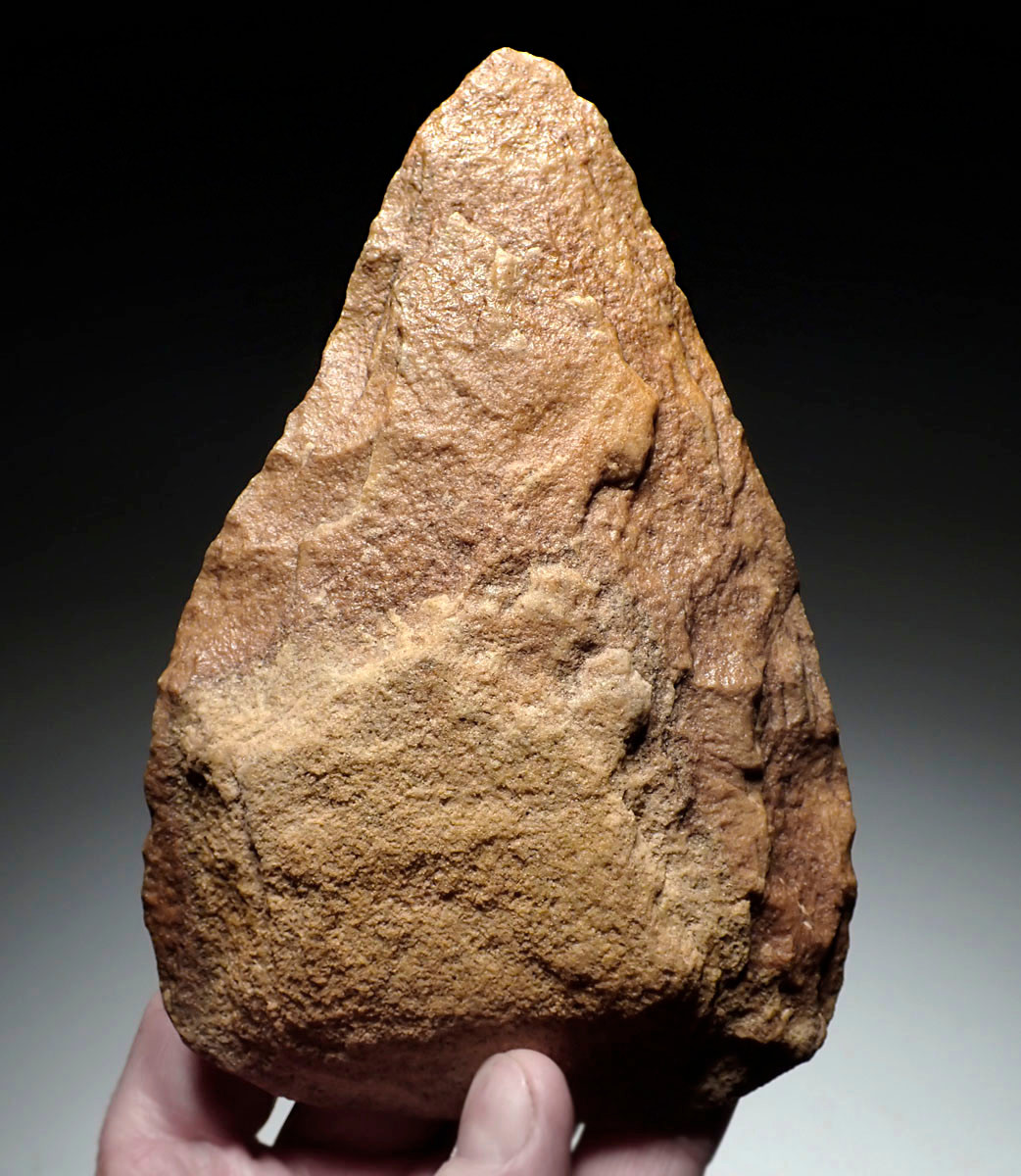 EXCEPTIONAL TRIANGULAR ACHEULEAN HAND AXE IN RED SANDSTONE MADE BY