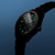 Reloj Tissot PRC 100 Solar Quartz con brazalete negro y esfera negra en un entorno estilizado - T1514221103100