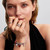 Modelo luciendo el Charm Pandora Cristal de Murano Rojo en plata de ley y color rojo junto a otros charms de plata - 794425C00