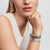 Modelo luciendo una combinación de charms incluyendo el Charm Separador Pandora Gemas Azul Hielo en plata de ley - 791359C01
