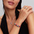 Modelo luciendo el Charm Pandora Stitch de Disney con Rosa Cristal de Murano en plata de ley junto a otras joyas - 794378C01