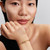 Modelo luciendo el Charm Besos Escrito a Mano dorado junto a otras joyas de Pandora - 764422C00