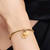 Modelo luciendo el Charm Colgante Pandora Doble Flor Mágica que brilla en la oscuridad de Enredados de Disney chapado en oro y color amarillo - 764020C01