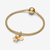 Charm Colgante Pandora Doble Flor Mágica que brilla en la oscuridad de Enredados de Disney en color amarillo y chapado en oro colocado en una pulsera - 764020C01