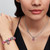 Modelo luciendo el Charm Pandora Caracol Rosa de plata de ley y esmalte rosa en una composición de joyas - 794553C01