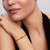 Modelo luciendo el Charm Mini Herradura de Pandora dorado chapado en oro en su muñeca - 764517C00