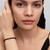Modelo luciendo el Charm Mini Herradura de Pandora dorado chapado en oro con pulsera de cordón negro - 764517C00