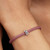Modelo luciendo el Charm Pandora Mini Símbolo Infinito Textura en plata de ley sobre una pulsera de cordón rosa - 794523C00