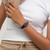 Modelo luciendo el Reloj Swatch Grace in Time con esfera azul y brazalete de silicona negra en vista lateral - LB188