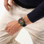 Modelo luciendo vista frontal del Reloj Swatch Swatch Neon Seppia SB02B104 con esfera negra y caja de plástico - SB02B104