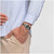 Modelo luciendo la vista lateral del Reloj Swatch Middlesteel con brazalete de acero y esfera verde - YLS468GC