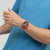 Modelo luciendo vista lateral del Reloj Swatch Camo Flash con esfera azul y brazalete de silicona naranja - SUSI400