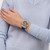 Modelo luciendo el Reloj Swatch Sidereal Glow con brazalete de goma azul y esfera marrón en vista lateral - YVS534