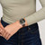 Modelo luciendo en la muñeca el Reloj Swatch Canyon Chaser con esfera negra y brazalete de piel marrón - YVS530