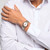 Modelo luciendo el Reloj Swatch Midimix YLS454GC con brazalete bicolor de acero y esfera blanca en la muñeca - YLS454GC