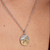 Modelo luciendo el Charm Medallón Zodiaco Capricornio de Pandora en plata y oro con circonita en un collar - 764987C01