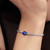 Modelo luciendo el Charm Mini Pez Azul de plata y esmalte azul en pulsera - 794899C01